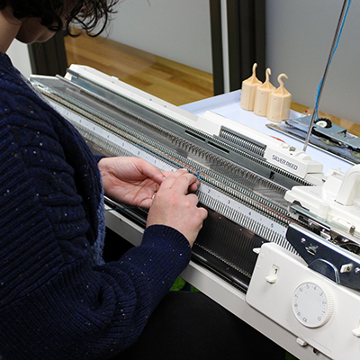 Photo of a person at a knitting machine