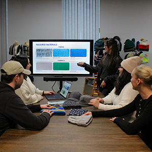 Photo of the Madison 88 workers at a meeting in front of a display